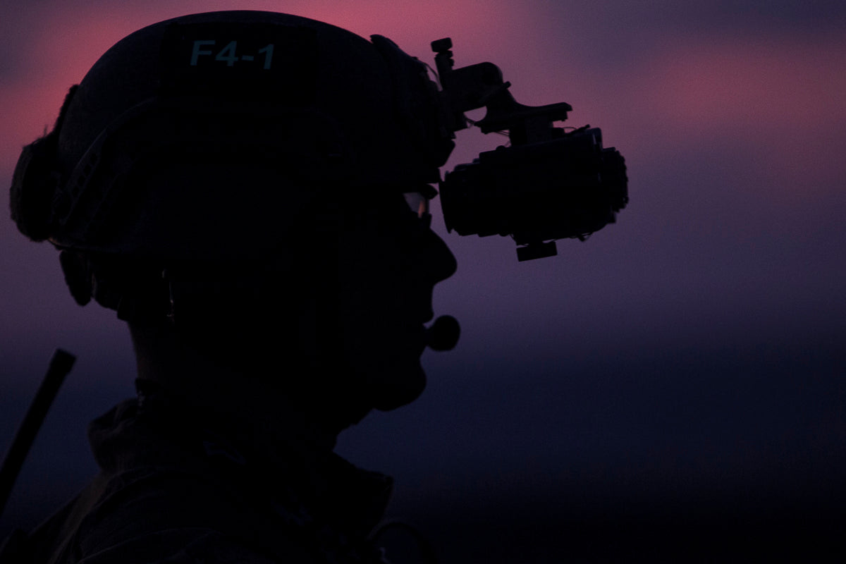 an image of a dual tube night vision goggles attached or mounted on a helmet that is being used by what looked to be a military personal on the night