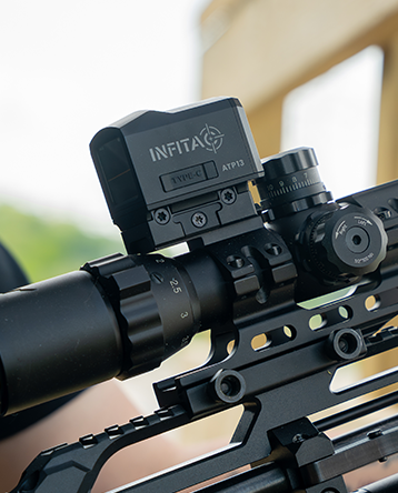 Detailed side view of the INFITAC ATP13 Thermal Reflex Sight mounted above a riflescope, showing the optic integrated with a precision air rifle and its Picatinny rail mounting interface.