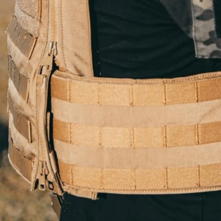 A close-up view of a tactical cummerbund that is being attached on a carrier vest.