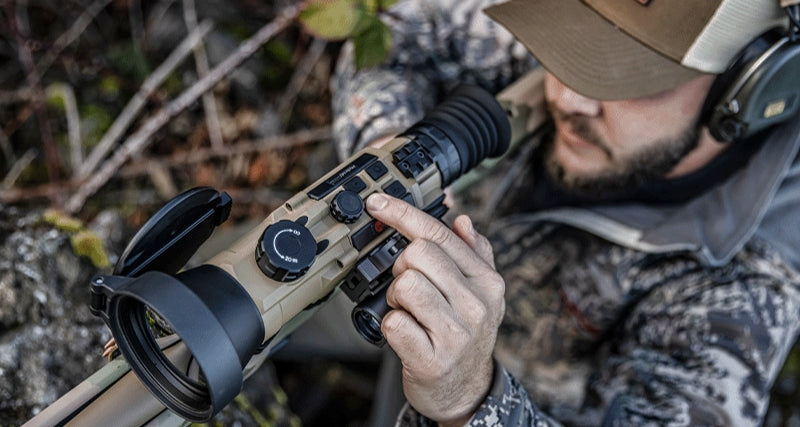 an image of a military personnel in what looks to be a field mission using a rifle that is in the color flat dark earth and has an iray scope attached on to it