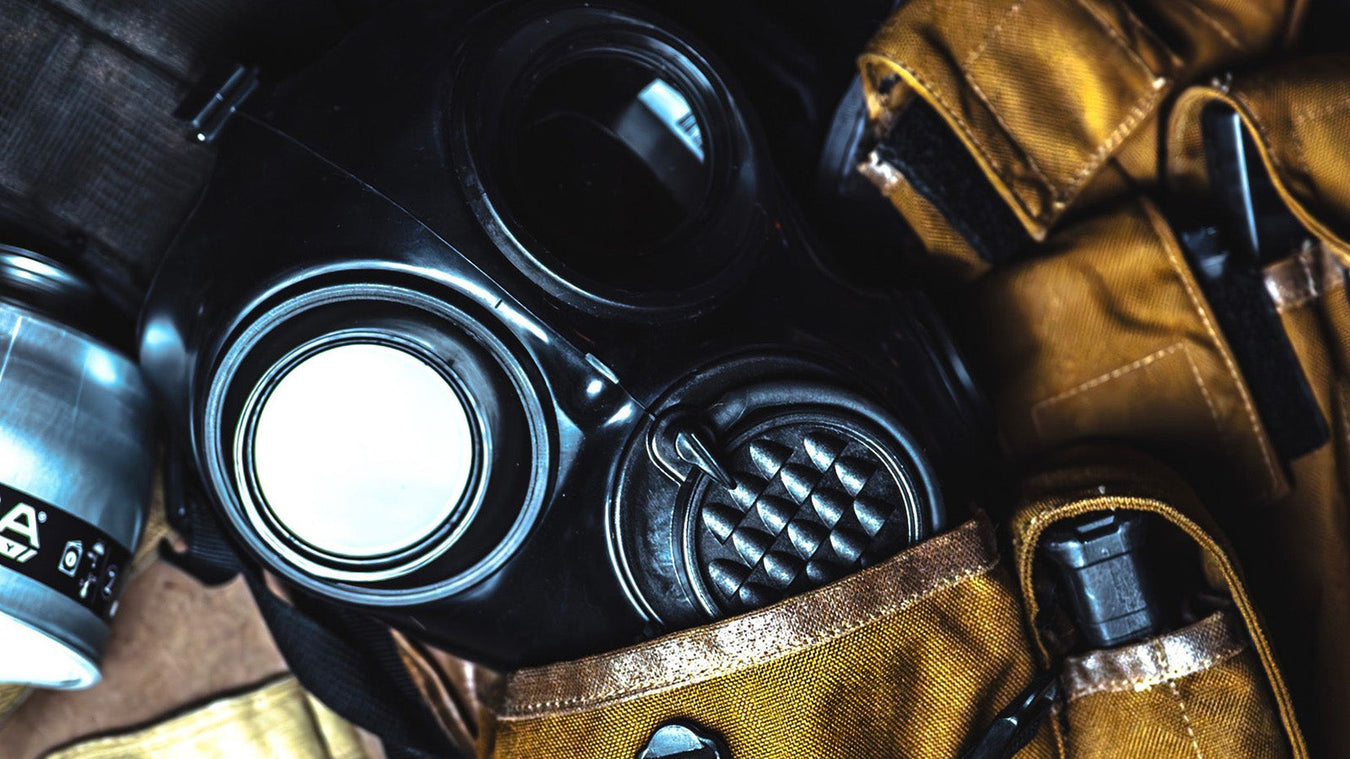 mira safety gas mask partially inserted into pocket of yellow jacket