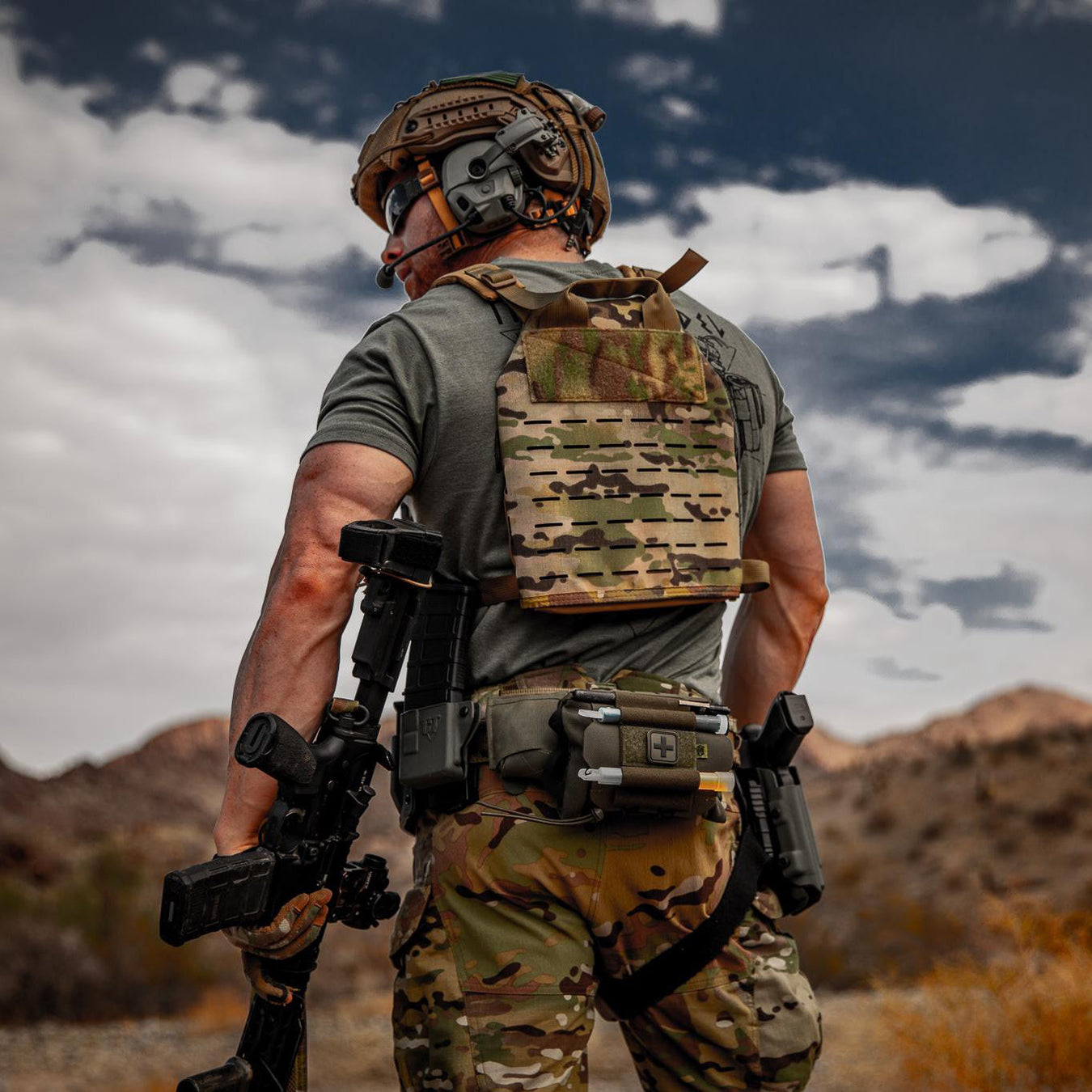 A soldier wearing tactical gears like a helmet and plate carriers while he is out on a mission.