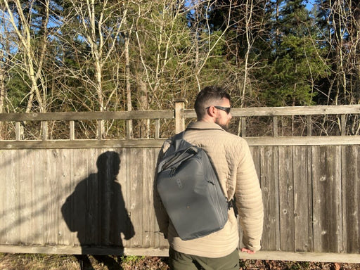 Back side view of the Eberlestock Fade Sling XL in black mounted to a Guy's Back.