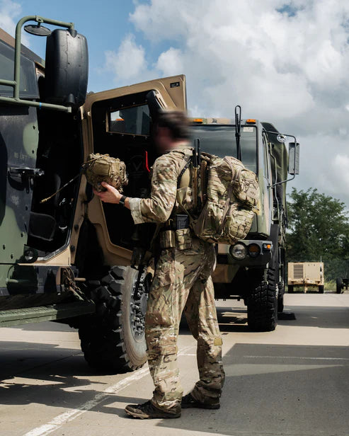 Operator jumping on an IFV while wearing a ROMAD Comms backpack.