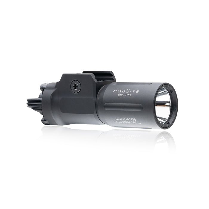 an image of the PL350 in the color black and has the OKW V2 light head where it is angled that you can see the right side of the item where the brand name and the words "dual fuel" is branded on it in white and we can see the attachment partition that attaches this light on a pistol.