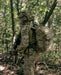 operator wearing a ROMAD comms backpack in multicam while scouting in the woods