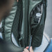 A close-up view showing the adjustable, hidden side water bottle pocket on the Gamut CCW Backpack, designed to secure hydration or gear without bulky external pouches.