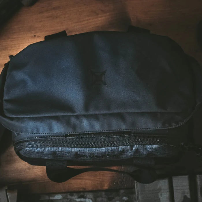 A direct top-down aerial view of the closed Vertx COF Light Range bag, showing the reinforced carry handle and the large U-shaped main zipper secured for transport.