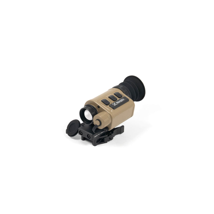 A frontal left angled isometric view of the Nocpix Micro 2 H25 25mm 640 Monocular, revealing the open objective lens aperture in the foreground, alongside the tan housing, top control buttons, and black rubber eyecup.