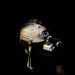 A left side angled view of the MICRO 2 H25 Multifunction Thermal Weapon Sight securely attached to a camouflage tactical helmet using a Wilcox G24 mount in a dark operational environment.