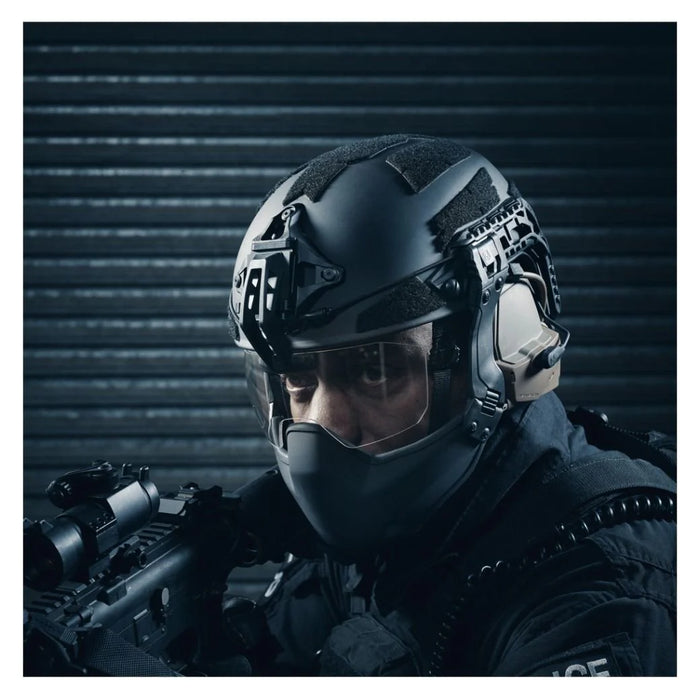 A lifestyle action shot showing an operator outdoors, wearing the protective jaw guard seamlessly integrated into the side rails of a tactical Galvion Caiman TL helmet.
