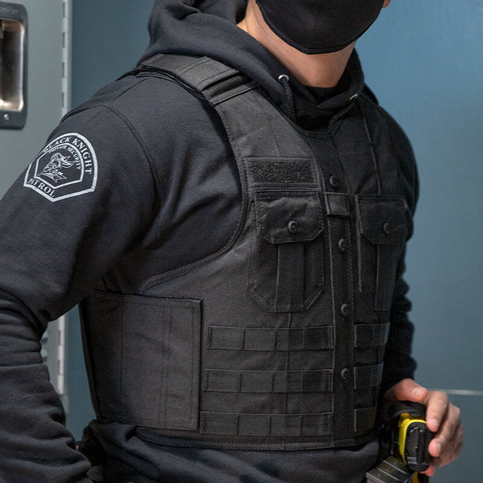 A police officer wearing the black safelife tactical uniform shirt carrier while on duty, demonstrating its professional appearance that blends seamlessly with standard law enforcement uniforms.
