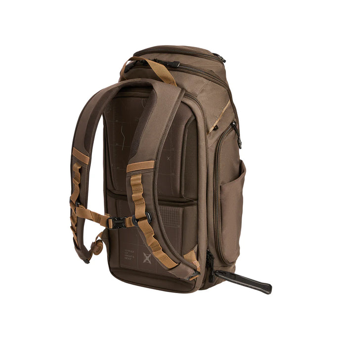 A rear-angled view of the Cedar Brown Gamut 26L Backpack showing its padded shoulder straps, sternum strap, and expandable side water bottle pockets.