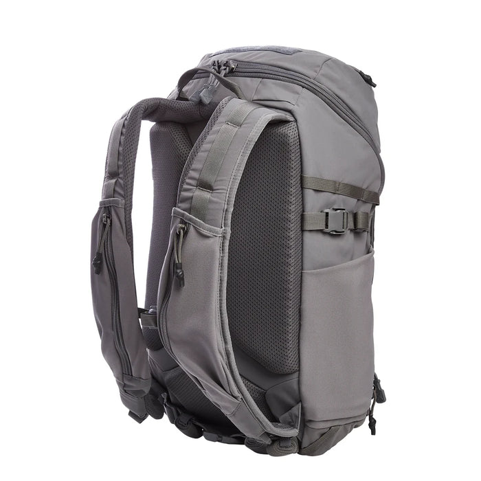 A rear-angled view of the Vertx Siege 25L tactical backpack features shoulder straps with easy-access compartments in the foreground and a breathable mesh back panel for airflow