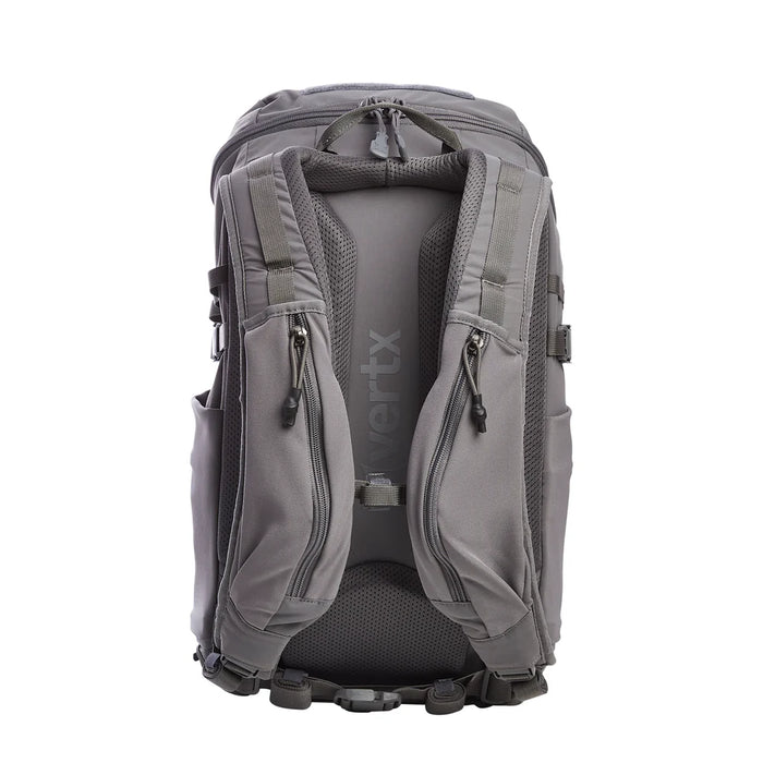 A rear view of the Vertx Siege 25L features shoulder straps with easy-access compartments in the foreground, while the sternum strap, waist belt, and breathable mesh back panel provide support and airflow