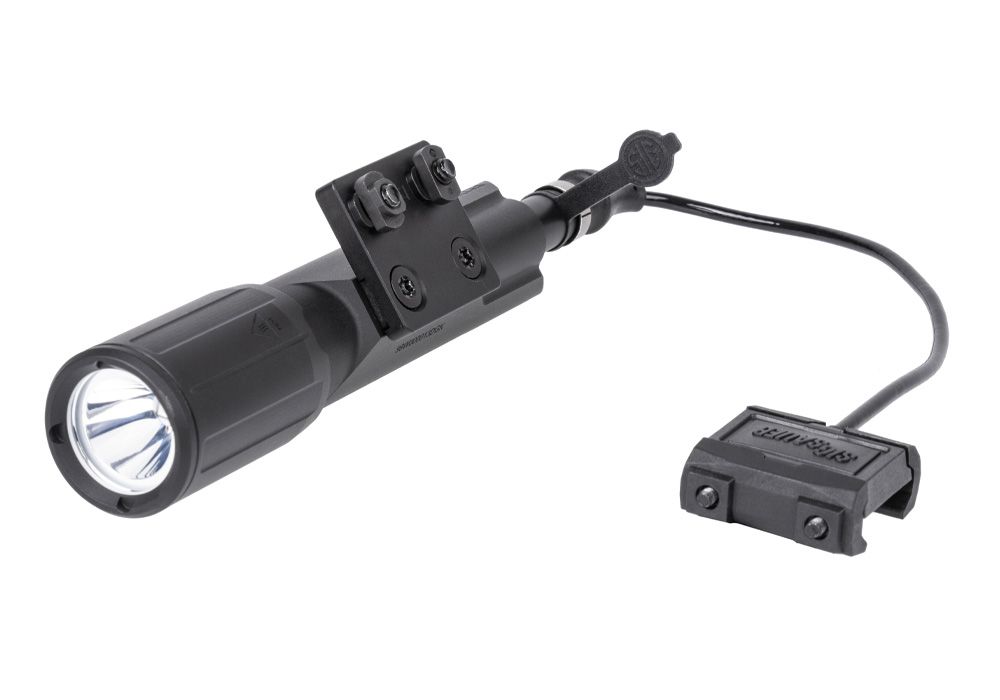 A right-angled frontal shot of the Sig Foxtrot MSR Full Size Rail Mounted White Light, displaying the remote tape switch with SureFire compatible plug and other included accessories.