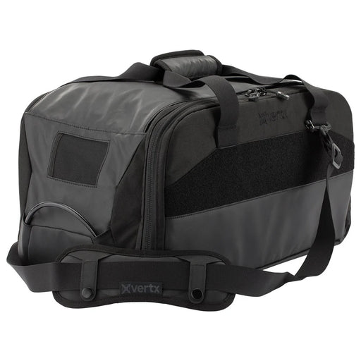 A side-angled shot of the vertx heavy range bag showing the durable padded shoulder strap in the foreground and the side caddie compartment situated in the second plane.