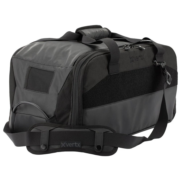 A side-angled shot of the vertx heavy range bag showing the durable padded shoulder strap in the foreground and the side caddie compartment situated in the second plane.