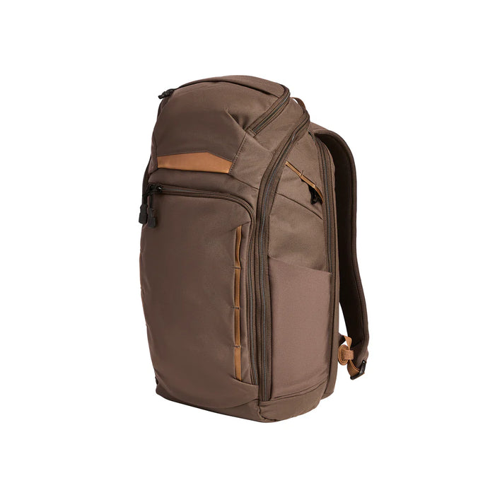 A side-angled view showing the exterior details of the Vertx Low-Profile 26L Backpack in the Cedar Brown.
