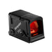 Front-left angled view of the Aimpoint COA enclosed red dot sight, highlighting the large red-tinted viewing window and compact optic housing.