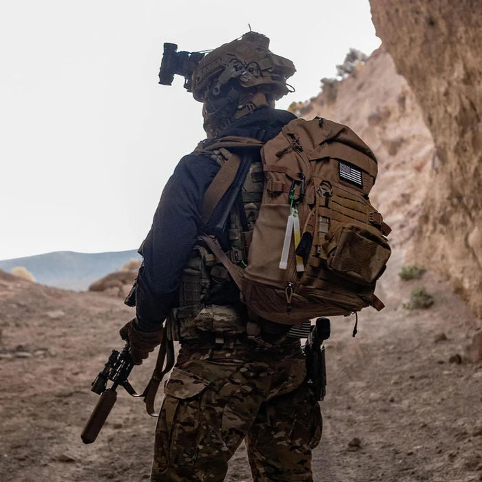 An operator wears the Vertx Siege 25L tactical backpack in Coyote for concealment and is fully equipped for their next mission.