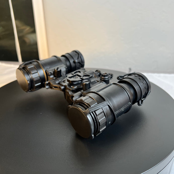 This side profile of the night vision goggles shows the articulating pods in an open position , highlighting the professional-grade build of this genuine AN/PVS-31D for sale with the eyecaps securely closed to guard the optics.