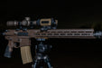 rh25 v2 thermal Optimized Alt Text: An AR-15 rifle setup at night, featuring an rh25 v2 thermal device mounted as a clip-on sight in front of a Nightforce magnified scope.