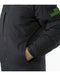A side view of the black Arcteryx Cold WX Jacket showing a person tucking a gloved hand into the insulated lower torso pocket, which is designed to keep hands warm during cold weather operations.