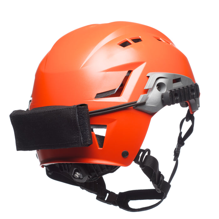 A right-side angled view of the black team wendy exfil counterweight kit in the large size, showing the secure mounting on a high-visibility orange SAR helmet for search and rescue balance.