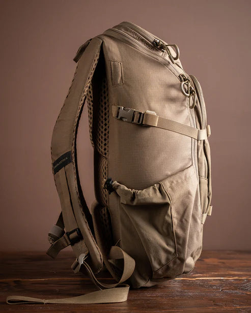 A profile side view of the Brute Scout Pack showing the heavy-duty compression straps pulled tight and the stretch side water pouch in the foreground, designed to keep hydration and optics easily accessible while on the move.