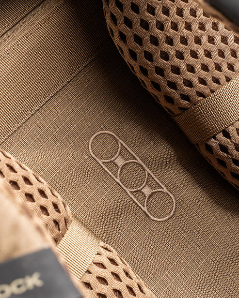 A high-detail close-up shot of the iconic Eberlestock logo embroidered on the rear of the Eberlestock Brute 3500 Weekend Hunting Pack, representing the quality and field-proven reliability of this professional gear.