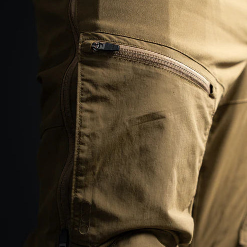 A close-up frontal view of the Coyote Brown Eberlestock Deadwood Bottoms, highlighting the durable midweight nylon texture and reinforced stitching designed for field use.