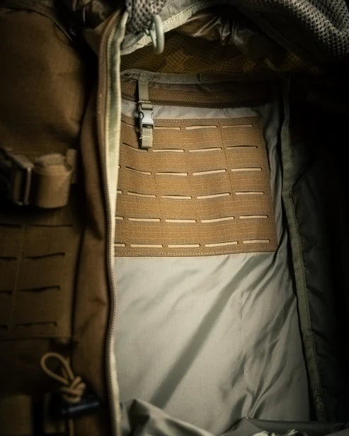 A detailed close-up inside the main compartment of the coyote brown pack, revealing the internal laser-cut MOLLE webbing panel that is designed to hold heavy radio equipment, highlighting its function as a true Military Comms Rucksack.