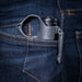 Close-up of a grey SwitchBack ring and flashlight tail-cap clipped to a dark blue denim pocket.