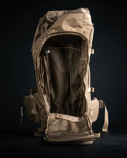 A top-down close-up shot shows the main compartment of the Eberlestock Brute 6500 105L Expedition Hunting Pack wide open, revealing the massive internal storage space and the reinforced ripstop lining.