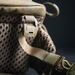 A close-up detail of the durable quick-release buckle and nylon strap connecting to the breathable air-mesh back panel, a common feature on modular eberlestock packs.
