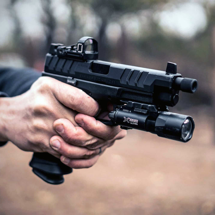 close up shot of person holding handgun equipped with surefire x300u-a weaponlight for gallery