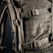 A detailed close-up showing the heavy-duty side compression straps of the backpack as they securely attach to the Mission EMOD System frame, demonstrating the pack's modularity and load-bearing stability.