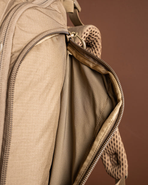 A detailed close-up shot of the deep side pocket on the Eberlestock Brute 3500 2 Day Backpack, perfectly sized to secure a spotting scope or large water bottle during rugged mountain treks.