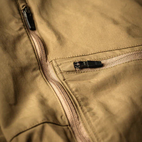 A close-up view of the Eberlestock Deadwood Trousers focusing on the front utility pocket and the two-way side vent zippers used for cooling during high-output activity.