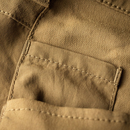 A close-up view of the knife pocket on the Eberlestock DeadwoodPants, showing the reinforced opening designed to securely hold tools during active movement.