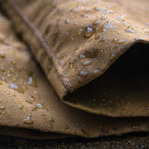 A close-up view of the leg cuff on the Deadwood Bottoms repelling water droplets, demonstrating the effective DWR finish designed to keep the fabric dry in wet environments.