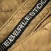 A close-up view of the waistband on the Eberlestock Deadwood, featuring the non-post button closure designed to prevent digging while wearing a heavy pack belt.