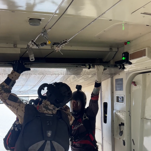 CORE Survival Portable Jump Light attached to the upper right corner of an aircraft compartment while two airborne operators train.