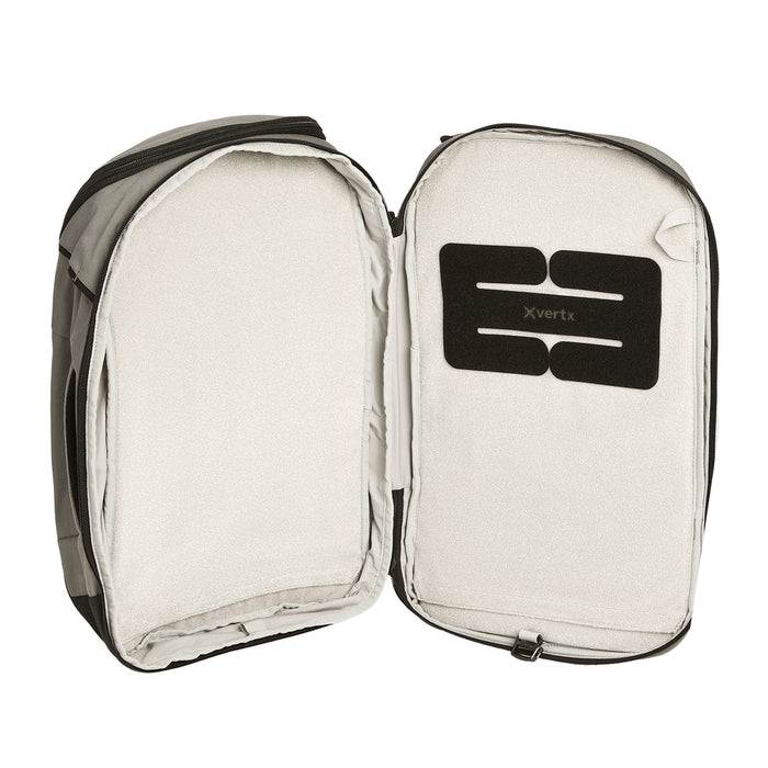 A detailed look inside the defensive compartment of the Vertx Gamut 22 Sling, showcasing the extensive loop lining and integrated BAP strap used for securing holsters and tactical accessories.