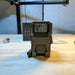 the dot ehs 1 holographic sight that is taken out of its box and is placed on top of the wooden desk with its back facing the camera