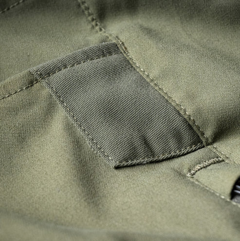 Close-up view of the reinforced side knife pocket on the Fall Green Eberlestock Camas Pro Pants, designed to withstand daily clip wear.