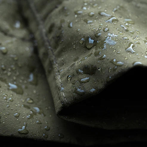 Close-up shot of the leg hem on the Eberlestock Camas Pro Soft Shell Pant, demonstrating the water-repelling capabilities of the DWR-coated stretch nylon fabric.