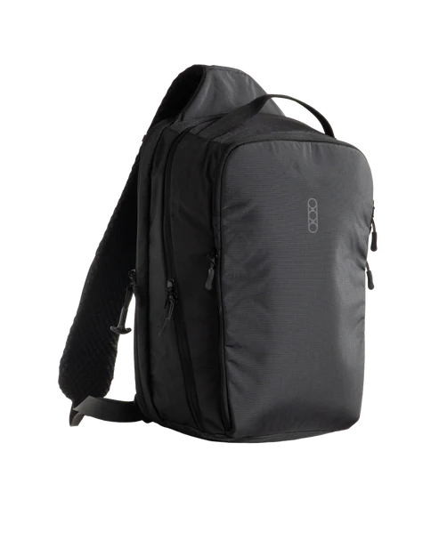 Eberlestock Fade Sling XL in black, front three-quarter view showing the padded shoulder strap, top carry handle, and multiple zippered front pockets.
