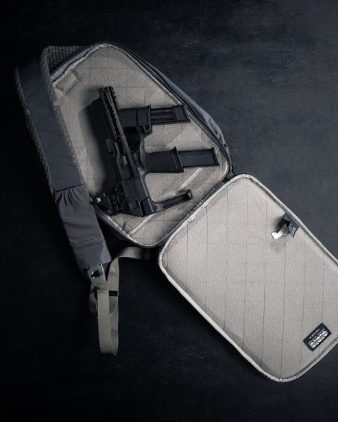 Interior view of the Eberlestock Fade Sling XL's dedicated CCW compartment, open to show the loop-lined panel holding a handgun and a spare magazine in place.